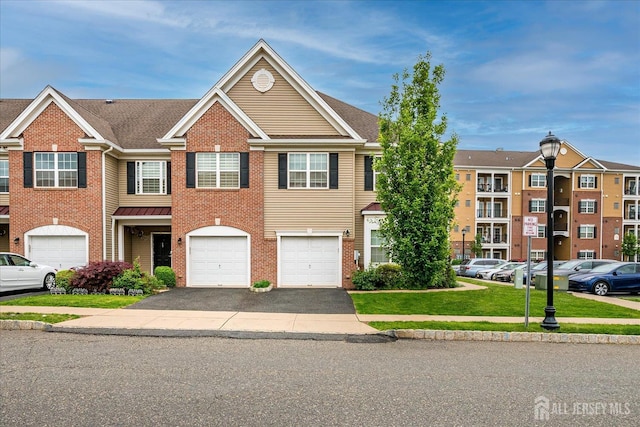 townhome / multi-family property with driveway, a garage, brick siding, and a front lawn