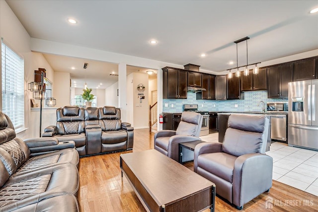 living room with light wood-style flooring and recessed lighting