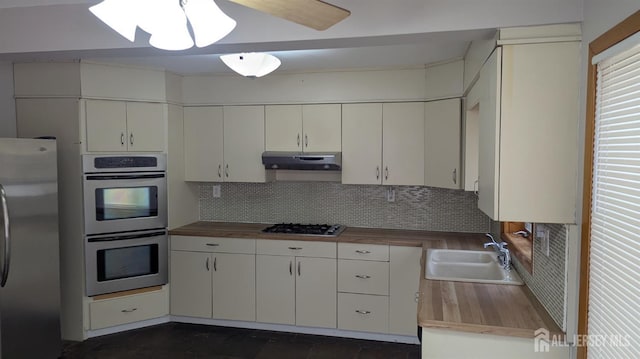 53 Suydam St, New Brunswick, NJ 08901 - kitchen with appliances with stainless steel finishes, wooden counters, a sink, and under cabinet range hood