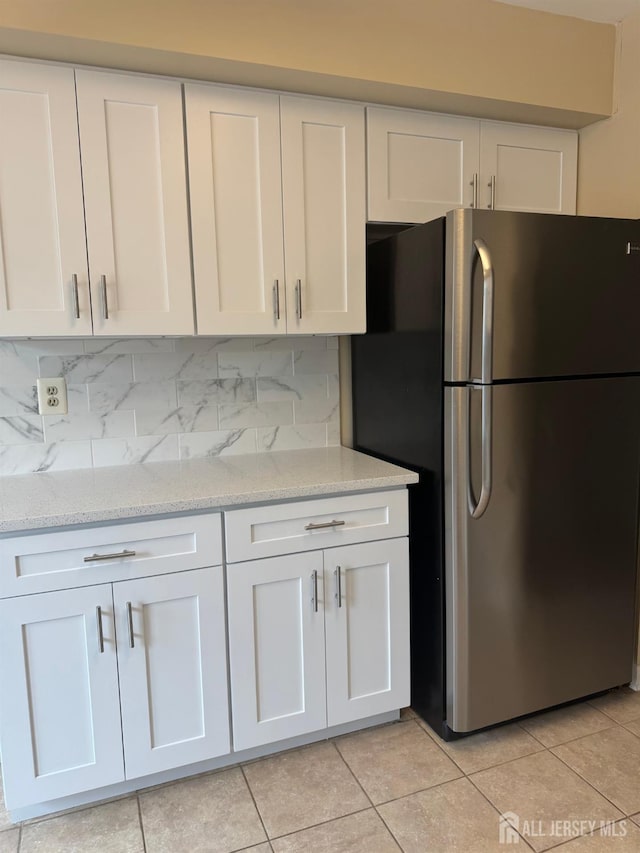 112 Biscayne Ct Unit 8, West Windsor, NJ 08540 - kitchen featuring freestanding refrigerator, white cabinetry, light stone counters, and light tile patterned floors