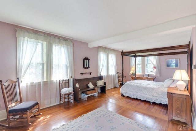 bedroom featuring beamed ceiling and wood-type flooring