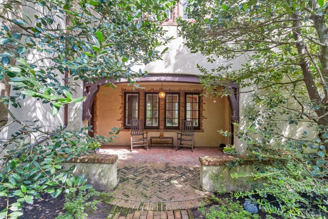 rear view of house with covered porch and french doors