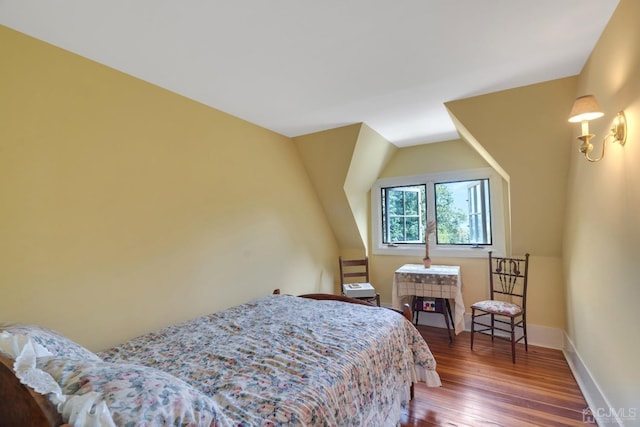 bedroom featuring dark wood-type flooring and vaulted ceiling