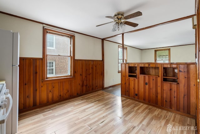 678 Bingle St, Perth Amboy, NJ 08861 - unfurnished room with wooden walls, plenty of natural light, light wood-style floors, wainscoting, and a ceiling fan