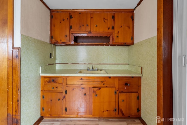 678 Bingle St, Perth Amboy, NJ 08861 - kitchen with a sink, light countertops, light wood finished floors, and brown cabinets