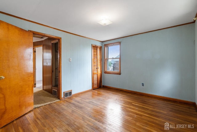 678 Bingle St, Perth Amboy, NJ 08861 - empty room featuring crown molding, wood-type flooring, baseboards, and wood walls