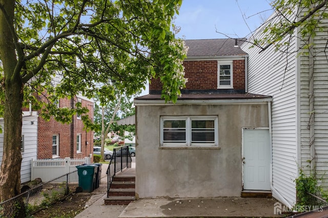 678 Bingle St, Perth Amboy, NJ 08861 - rear view of property featuring roof with shingles, brick siding, and stucco siding