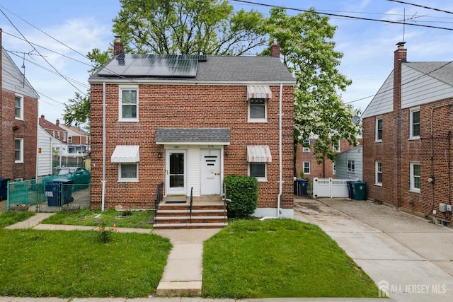 678 Bingle St, Perth Amboy, NJ 08861 - view of front of home with a chimney, brick siding, and solar panels