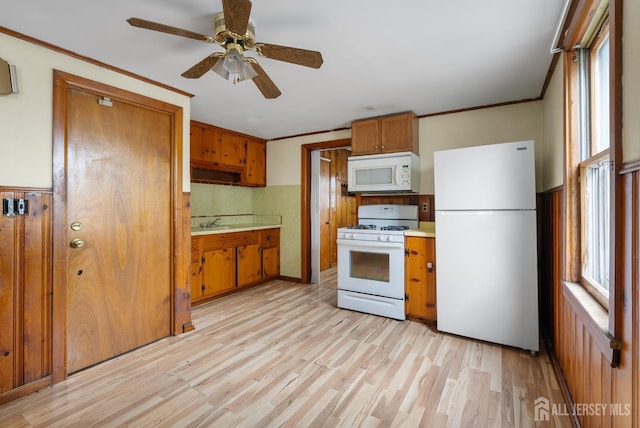 678 Bingle St, Perth Amboy, NJ 08861 - kitchen featuring white appliances, brown cabinets, light countertops, light wood-type flooring, and ornamental molding