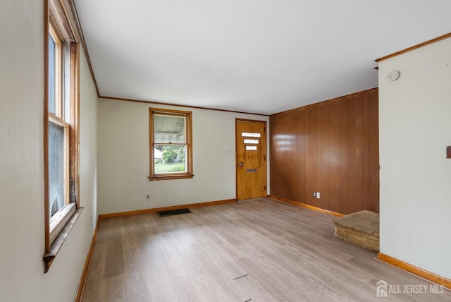 678 Bingle St, Perth Amboy, NJ 08861 - unfurnished room featuring light wood-type flooring, baseboards, crown molding, wooden walls, and a smoke detector