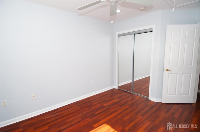 unfurnished bedroom featuring dark wood-type flooring, ceiling fan, and a closet