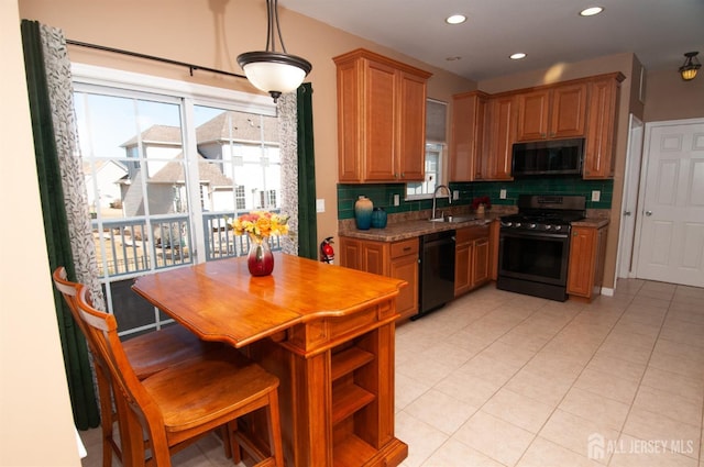 kitchen featuring sink, dishwasher, hanging light fixtures, stainless steel range with gas stovetop, and light stone countertops