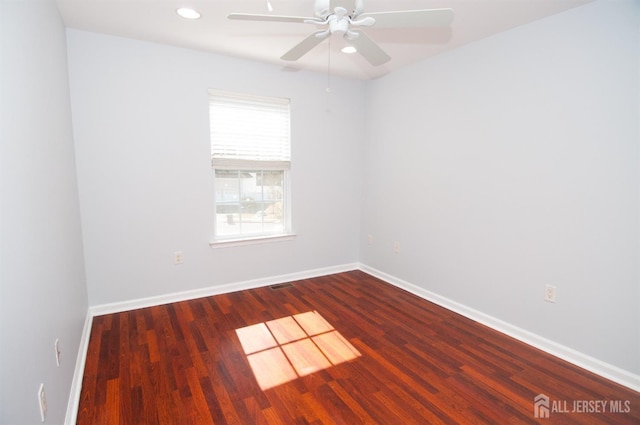 empty room with dark wood-type flooring and ceiling fan