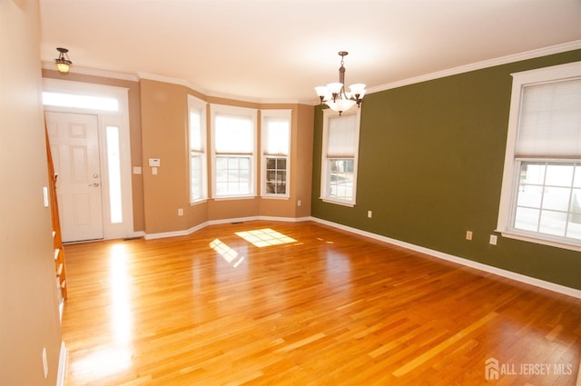 interior space with crown molding, a notable chandelier, a wealth of natural light, and light wood-type flooring