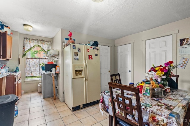 209 New St, New Brunswick, NJ 08901 - kitchen with white refrigerator with ice dispenser, light tile patterned floors, a textured ceiling, and light countertops