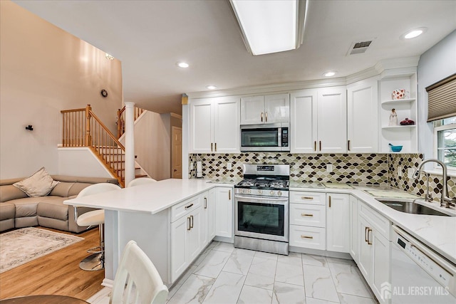 7 Cambridge Ct, East Brunswick, NJ 08816 - kitchen featuring stainless steel appliances, a peninsula, open floor plan, white cabinetry, and backsplash