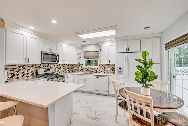 7 Cambridge Ct, East Brunswick, NJ 08816 - kitchen with stainless steel appliances, a peninsula, open shelves, light stone counters, and white cabinetry