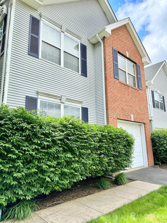 7 Cambridge Ct, East Brunswick, NJ 08816 - view of front of house with an attached garage and brick siding