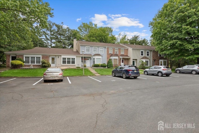 11 Excalibur Ct, Old Bridge, NJ 08857 - view of front of home featuring uncovered parking, a chimney, brick siding, and a front yard