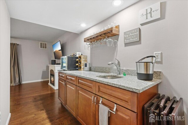 11 Excalibur Ct, Old Bridge, NJ 08857 - kitchen featuring brown cabinets, dark wood-style flooring, recessed lighting, light stone counters, and stainless steel microwave