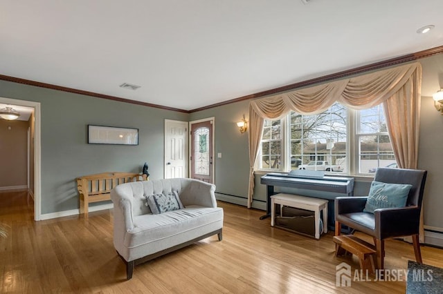 living room with visible vents, ornamental molding, baseboards, and wood finished floors