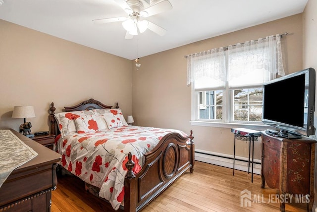 bedroom featuring ceiling fan, wood finished floors, and a baseboard radiator