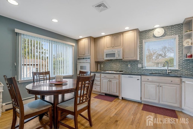 kitchen with visible vents, light wood-style floors, plenty of natural light, white appliances, and a sink