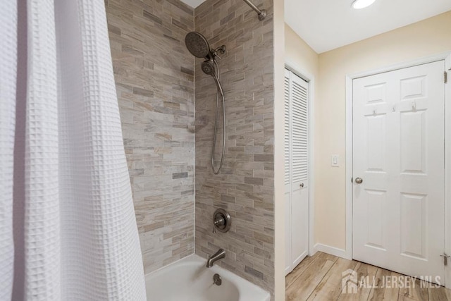 full bathroom featuring baseboards, wood finished floors, and shower / bath combination with curtain