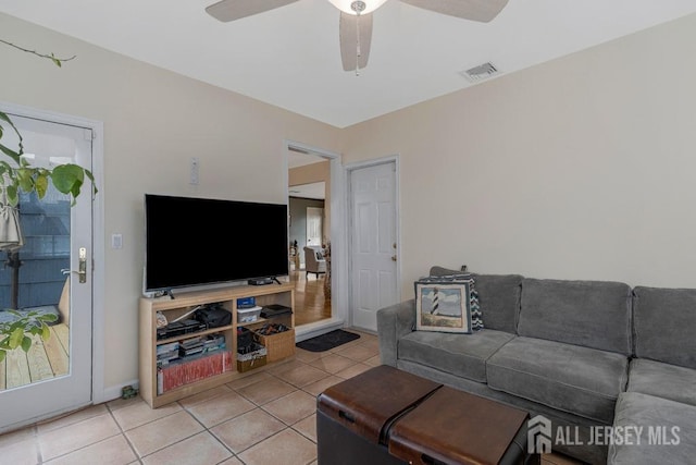 living area with light tile patterned flooring, visible vents, and ceiling fan