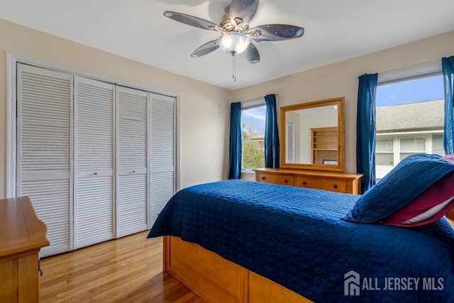 bedroom featuring a ceiling fan, light wood-type flooring, and a closet