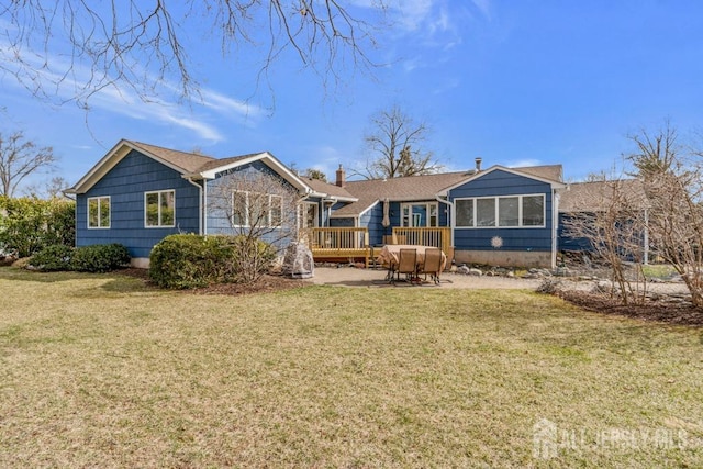 back of property with a yard, a patio area, a sunroom, and a wooden deck