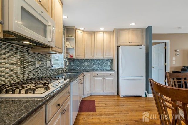 kitchen featuring open shelves, dark stone countertops, tasteful backsplash, white appliances, and light wood finished floors