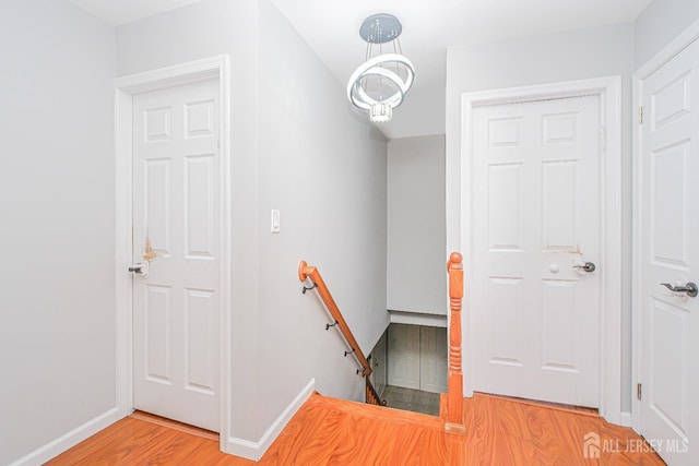 staircase featuring wood finished floors and baseboards