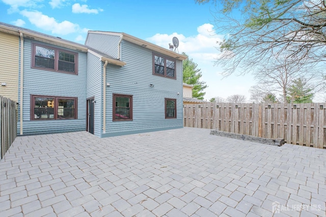 back of property with a patio and a fenced backyard