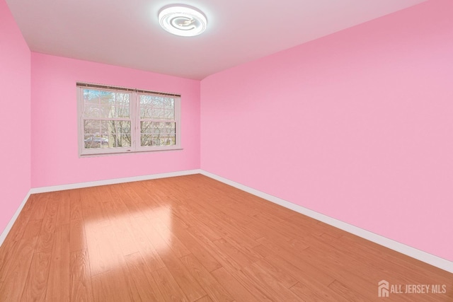 spare room with light wood-style floors and baseboards