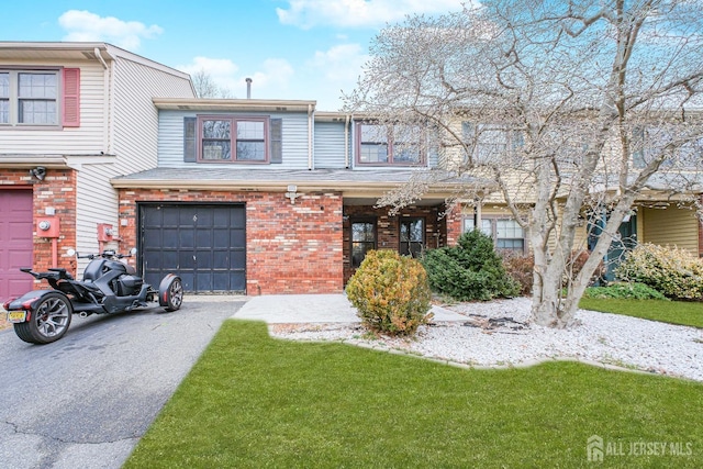 townhome / multi-family property featuring asphalt driveway, brick siding, and an attached garage