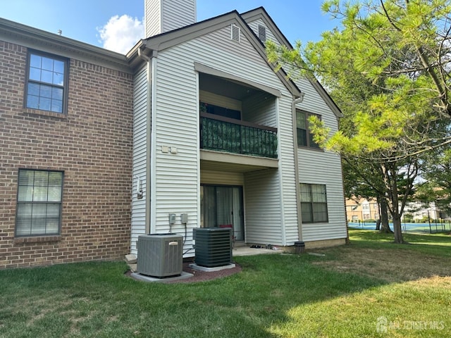 1202 Harbor Club Dr, Sayreville, NJ 08859 - rear view of property with central air condition unit, a chimney, brick siding, a balcony, and a yard