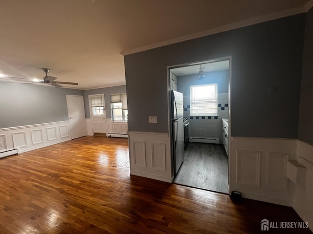 55 Gills Ln Unit 64, Iselin, NJ 08830 - empty room featuring a baseboard radiator, crown molding, wood finished floors, a ceiling fan, and wainscoting