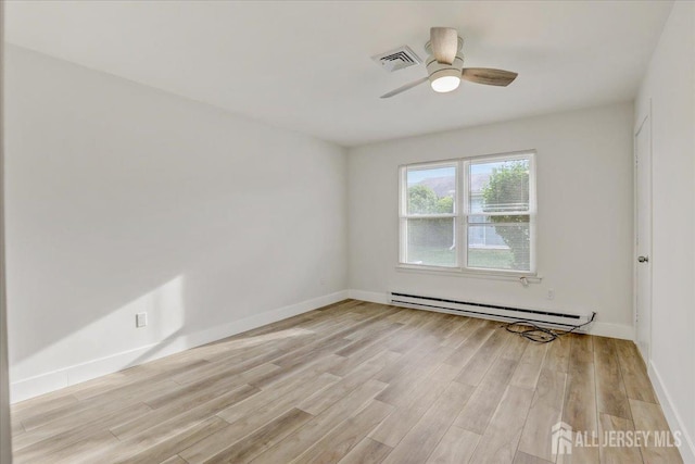 spare room with light wood-type flooring, baseboards, visible vents, and baseboard heating