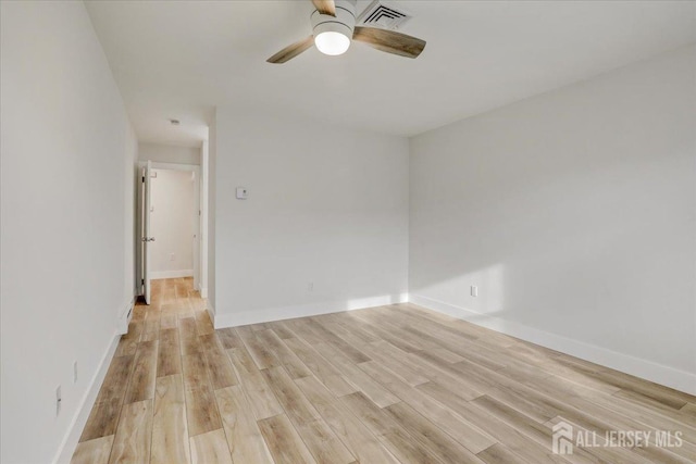 unfurnished room with a ceiling fan, baseboards, visible vents, and light wood finished floors