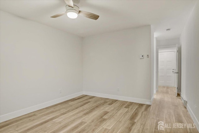 unfurnished room featuring light wood finished floors, ceiling fan, and baseboards