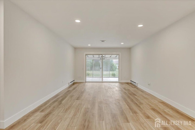 spare room with light wood-type flooring, baseboard heating, baseboards, and recessed lighting