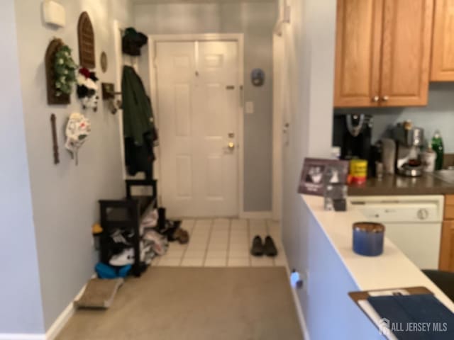 kitchen featuring dishwasher, baseboards, and light tile patterned floors