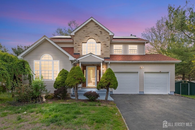 traditional home featuring solar panels and aphalt driveway