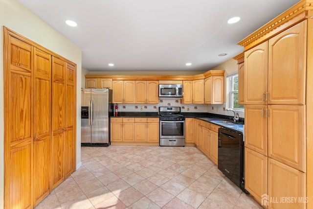 kitchen featuring light brown cabinets, dark countertops, recessed lighting, a sink, and appliances with stainless steel finishes