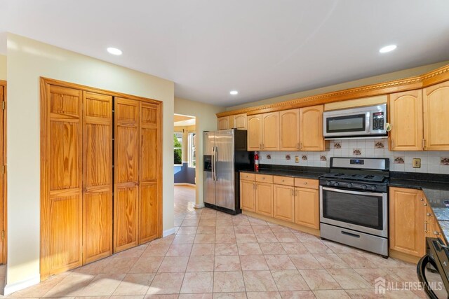 kitchen with light brown cabinets, dark countertops, recessed lighting, backsplash, and stainless steel appliances
