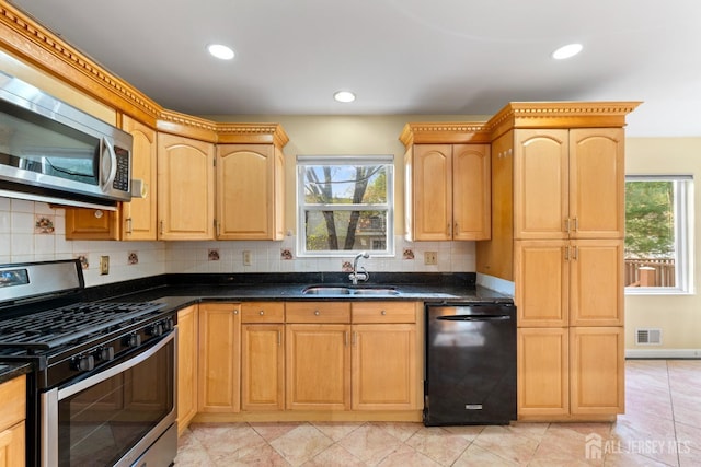 kitchen featuring backsplash, appliances with stainless steel finishes, a sink, and visible vents