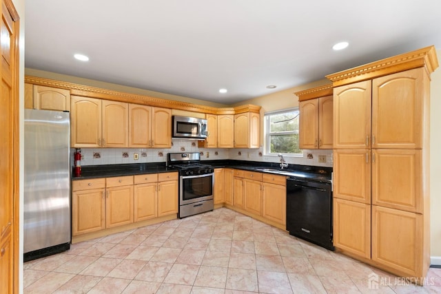 kitchen featuring light brown cabinets, dark countertops, a sink, backsplash, and stainless steel appliances