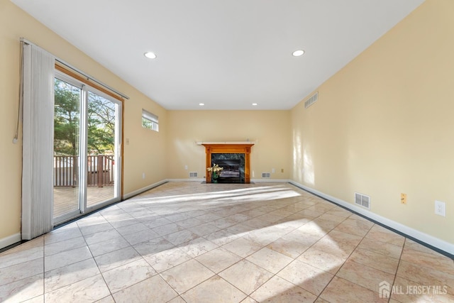 unfurnished living room with recessed lighting, baseboards, visible vents, and a fireplace with flush hearth