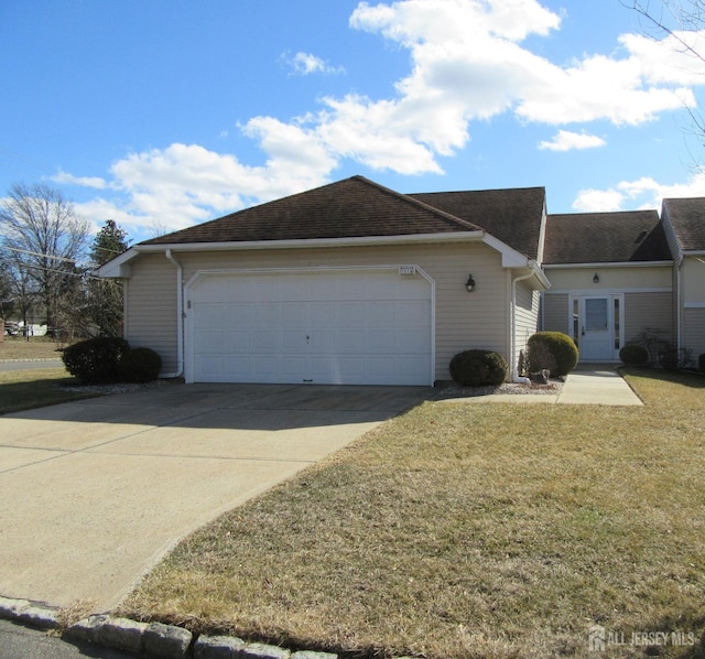 view of side of property featuring driveway, a garage, and a yard